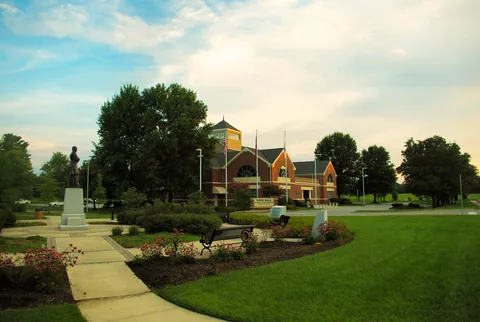Farragut Town Hall, a brick building across a landscaped lawn with a walkway and a statue.